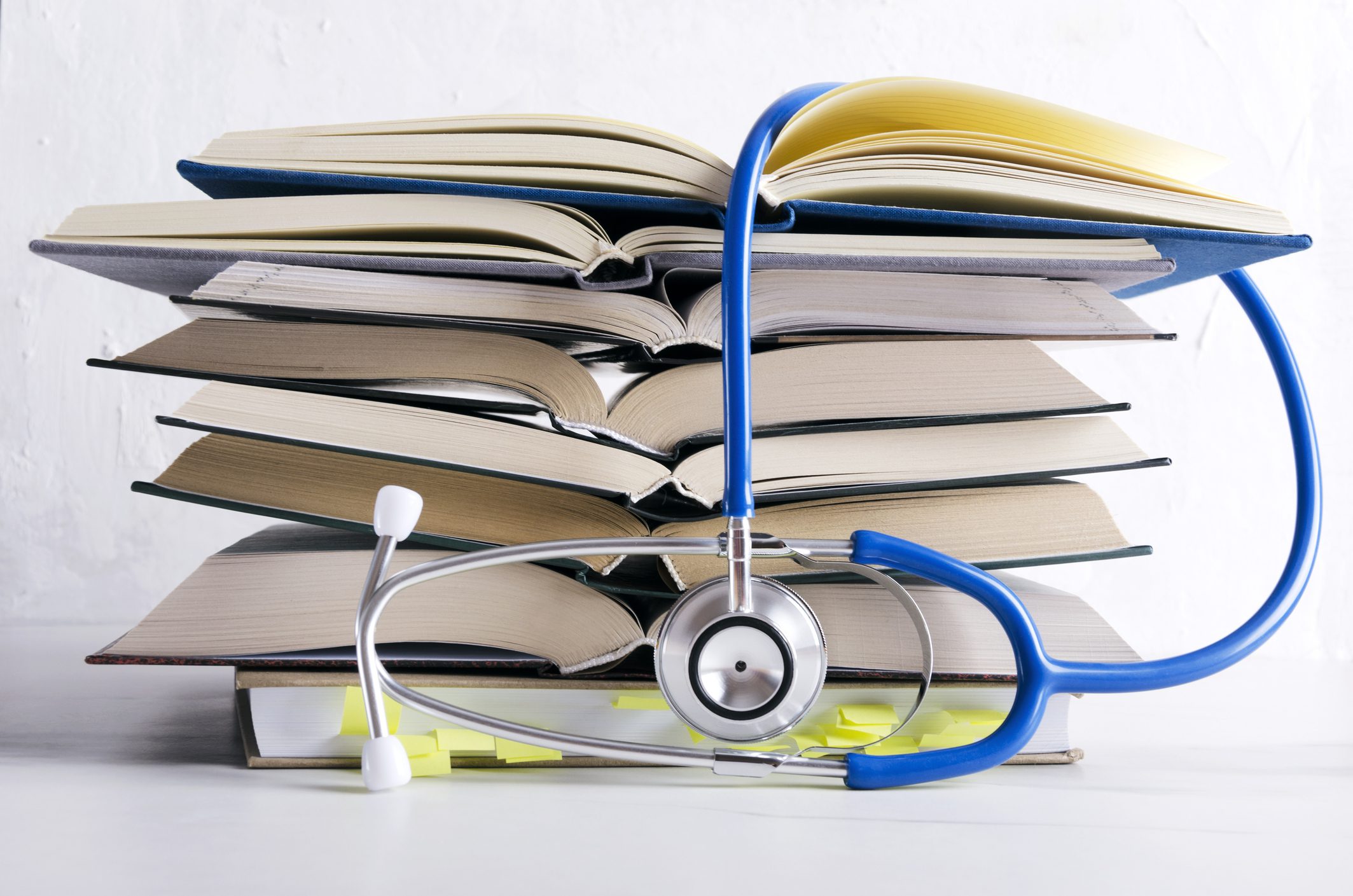 Medical knowledge. Pile of open books for medical student Dr. Daniel Bennett